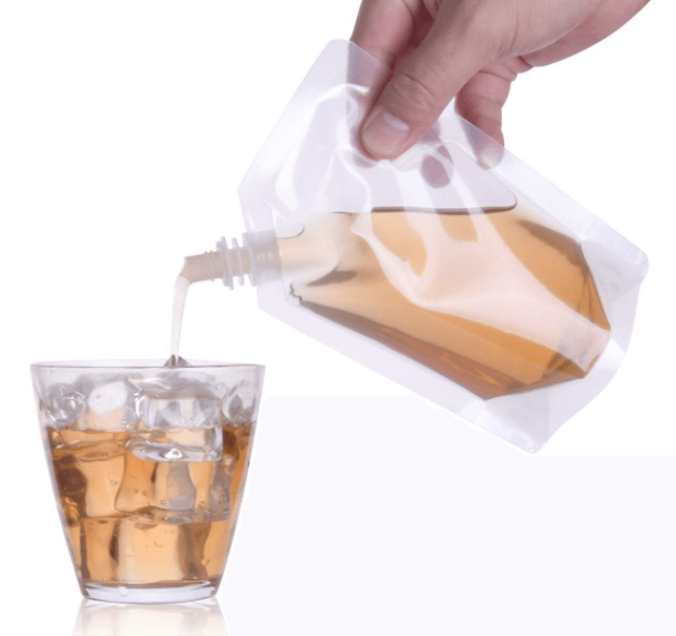 a hand pouring liquid into a glass of ice