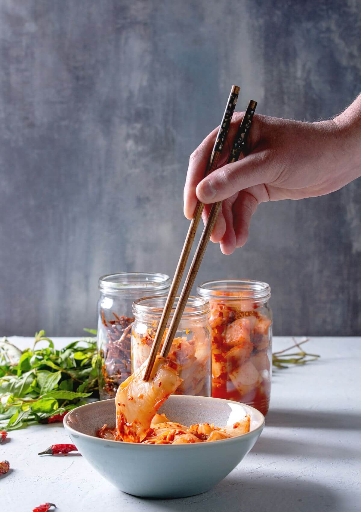 Someone digging into kimchi with chopsticks