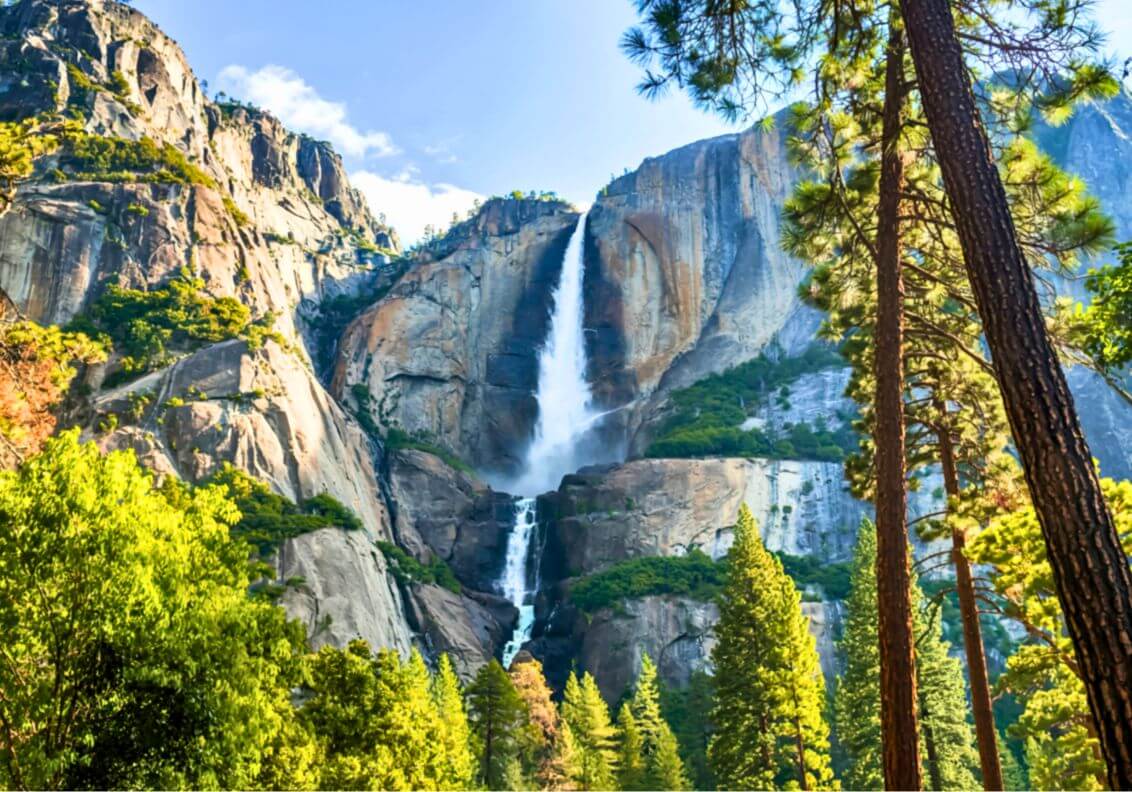 Majestic waterfall amidst towering cliffs.