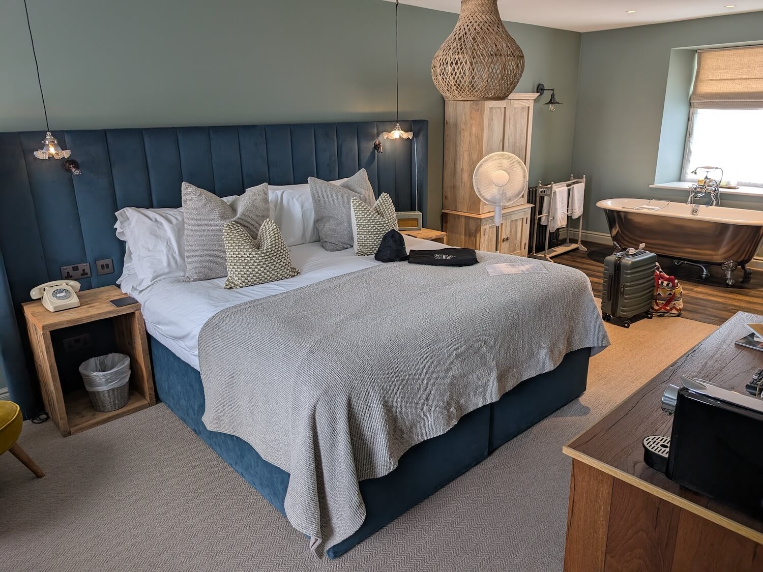 a bedroom with a blue bed and a tub