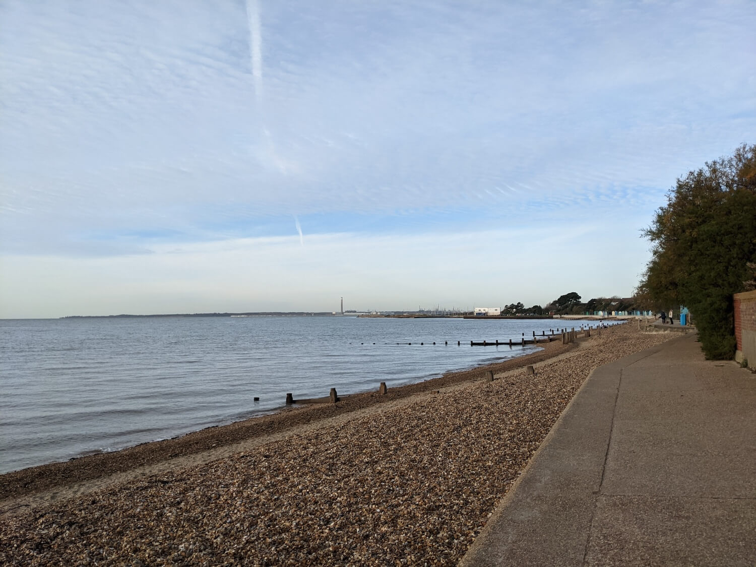 a beach with a body of water and a blue sky