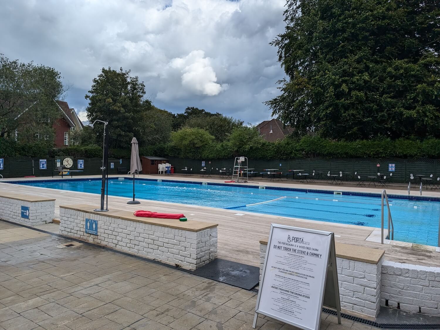 a pool with umbrellas and a sign